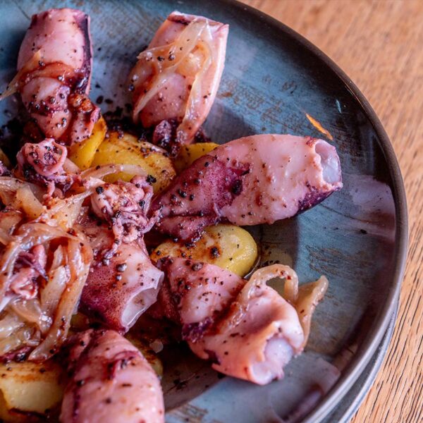 Chipirones encebollados con base de patatas panadera